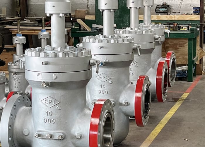Row of EPI 10-inch 900 silver gate valves with red flanges in workshop